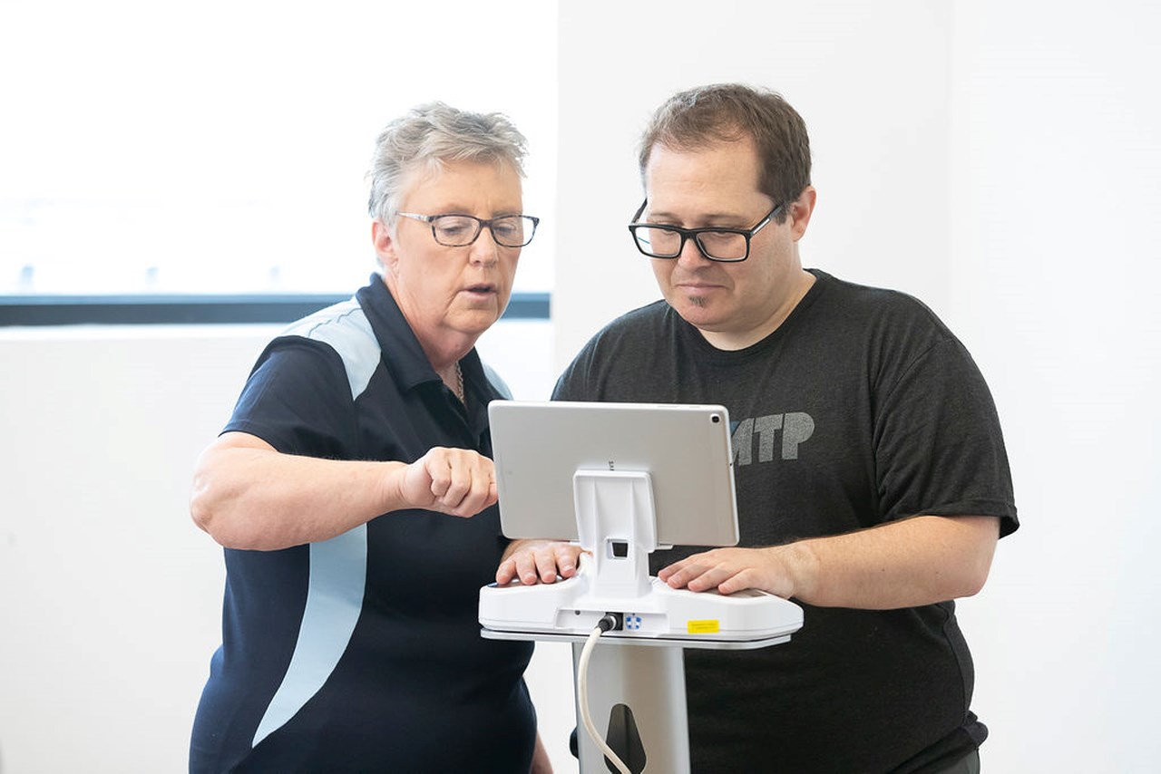 Susan Butcher Clinical Manager making an assessment to a man, with a machine, at Oedema Institute by SIGVARIS GROUP